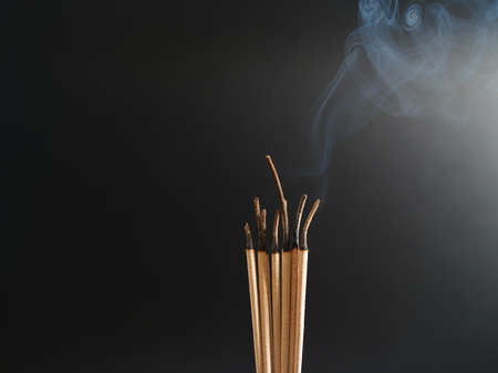 Burning incense white smoke black background used as a worship background image a sacred object of...