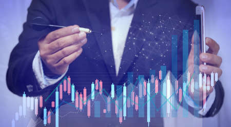 A young businessman uses smartphone embroidered darts to set goals and visions. There is a graph...