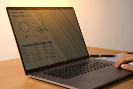 Business people use notebook programs in their offices to plan reports and analyze their income, expenses, and organizational growthの写真素材