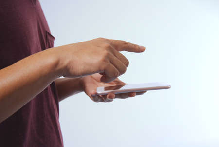 close-up white isolated background Man's hand using the smartphone for surfing the internet.の写真素材