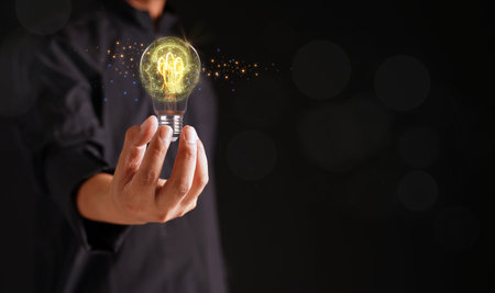 Businessmen touching palm light bulbs with glowing virtual brains and wire connected with imaginative creativity for inspiration and innovation with network concept, problem-solving black background.の写真素材