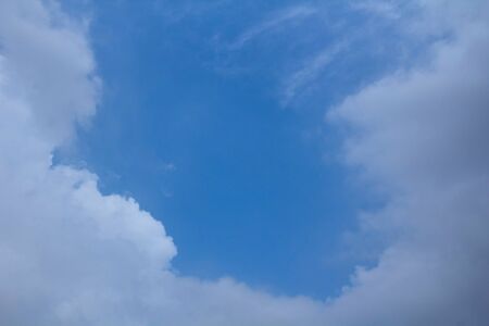 Blue sky with clouds around center space.の写真素材