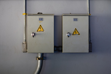 Two electricity control box with sign on the wall. electrical cabinet with warning signs and...