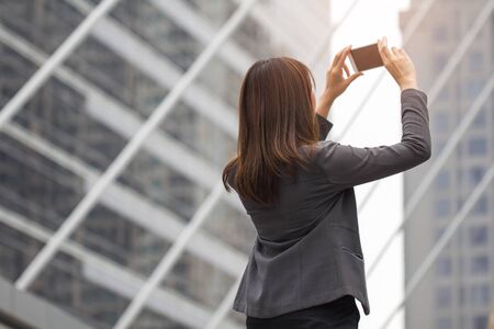 Business working womanin suit selfie, taking picture of  building in backgroundの写真素材