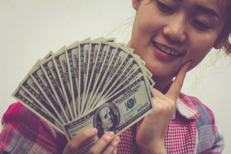Close up woman holding money, USA dollar notes. happy girl with money for shopping.の写真素材