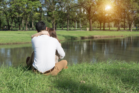 man hug woman in park outdoor, couple holding together back view. love valentine day concept.の写真素材