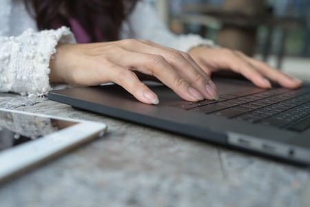 Closeup business woman's hands typing on laptop keyboard on desk with sunlight.
Female worker and business concept, using notebook computer on table in outdoor cafe.
Girl writing a blog. Lady casual working lifestyle, Soft focus.の写真素材