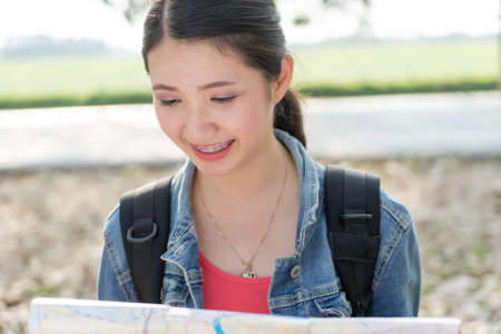 Beautiful young Asian woman standing with map in hands.の写真素材