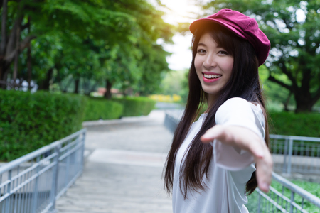 Beautiful young woman reaching hand back to boyfriend. leading girl walking follow lover. couple in love in nature vacation timeの写真素材