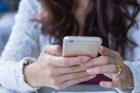 Close up female hands holding using mobile smart phone.
Business woman typing text messages on touch screen cellphone.の写真素材