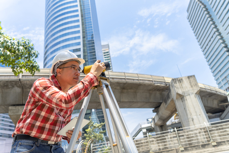 Civil engineer land survey with tacheometer or theodolite equipment. Worker Checking construction site on the road. Surveyor engineer making measuring with theodolite instrument level tool.の写真素材