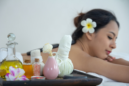 Beautiful young woman having massage with stones in spa salon.
Beauty woman relaxing in spa. Hot stone massage pebbles on back.の写真素材