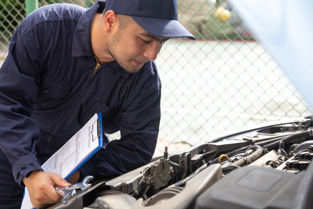 Specialist auto mechanic engineers and technicians in car service station, checking car engine...