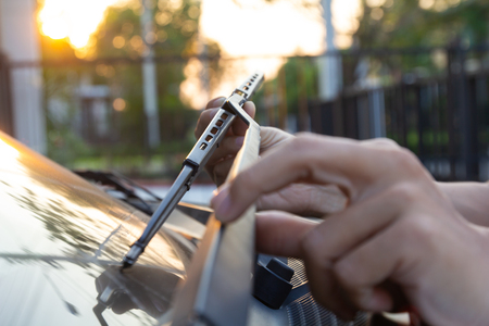 Man hand picking up car windscreen wiper.
Technician changing windshield wipers blade outdoor.
Mechanic check, replacing old wiper blade on customers car front window glass at car stationの写真素材