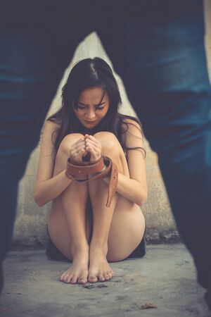 Man standing over woman body.
Woman bondage crying hands ties with belt rope, domestic violence life.の写真素材
