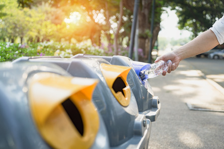 Waste management, Man throwing plastic bottle into recycle bin. Waste separation rubbish before drop to garbage bin to save the world, environment care. Pollution trash recycling management concept.の写真素材