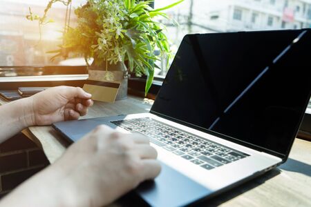 Businessman hand holding credit card using laptop computer typing keyboard.
Technology payment banking lifestyle 
Close up hands holding debit card making order for shopping online.の写真素材