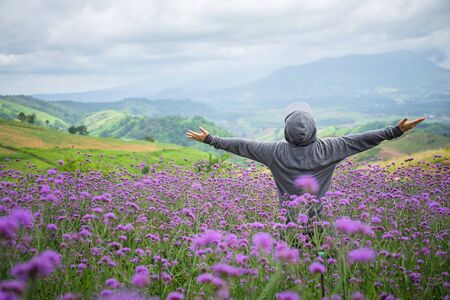 Happy of man standing alone on mountain with open arms raised up in verbena purple flower field in the morning. Enjoying  nature
Happy man gesture of triumph with arms raised in air.の写真素材
