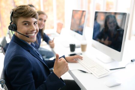 Call Center Service. Photo of customer support or sales agent.  Help line answering and telemarketing. Male caller or receptionist phone operator.Copy space for some text, advertising or slogan.の写真素材