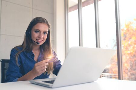 Young woman holding credit card and using a laptop computer. The girl has a credit card and a laptop. Online shoppingの写真素材