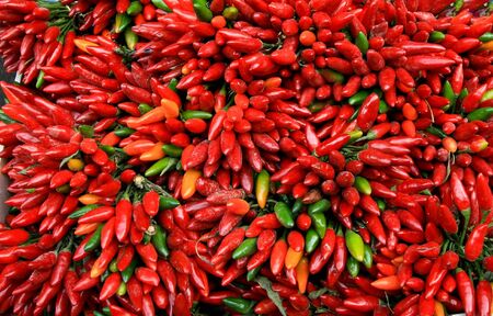 Lots of red and green chili peppers shot from overhead at outdoors market in Vienna Austriaの写真素材