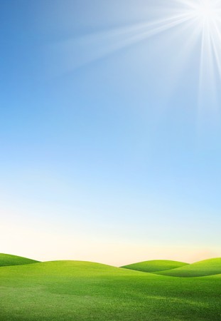 A green field with blue sky and cloudsの写真素材