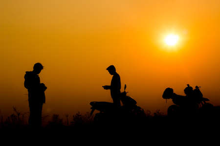 Biker man on silhouette and sunsetの写真素材