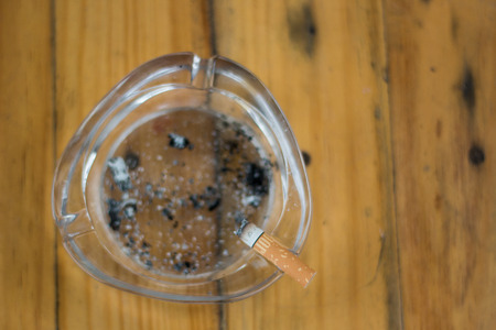 smoking in the ashtray on a wooden backgroundの写真素材