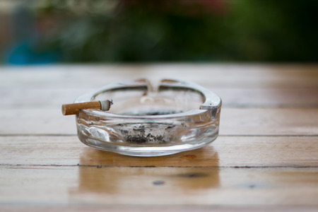 smoking in the ashtray on a wooden backgroundの写真素材