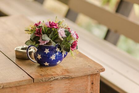 flowers in vase and ice coffee on wood table and blur backgroundの写真素材