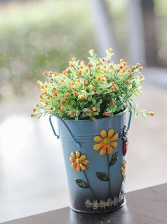 flowers in vase and ice coffee on wood table and blur backgroundの写真素材