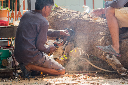 workers cut the big tree by chain saw on piece and scraps of woodのeditorial素材
