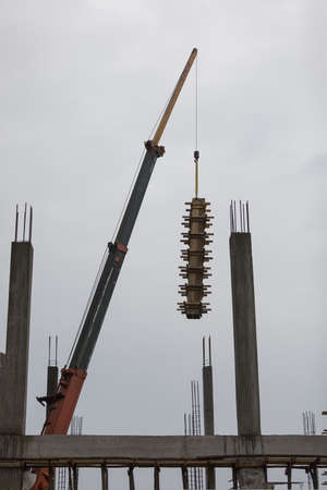 Workers makes column box and keep by crane for built columnの写真素材