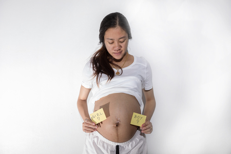 Teenager girl be pregnant in education age in white suit on isolated backgroundの写真素材