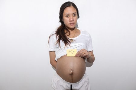 Teenager girl be pregnant in education age in white suit on isolated backgroundの写真素材