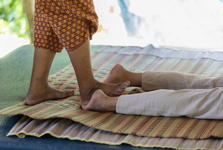 massage style Thai old culture by hands and foot knead on body for relax muscle from hard workの写真素材