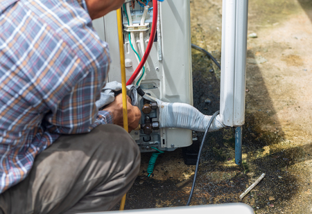The maintenance man repair air-condition and put-on liquid from gate valve on pressure limitの写真素材