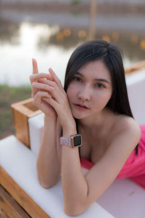 A smart model long dark hair and skin healthcare and body perfect in pink short dress, she take a photo is mini sexy dress and happy on evening on workの写真素材
