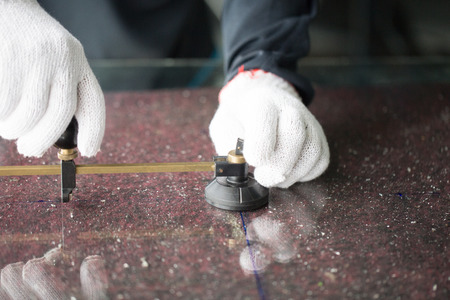 Closeup of Craftsmen cutting glass using tools for cutting glass.