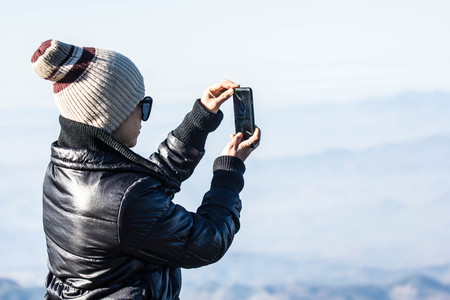 Tourists use the phone to take pictures of the mountains in the morning.の写真素材