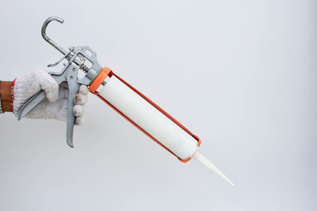 Construction workers installing windows and using siliconの写真素材