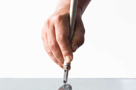 Glass technicians are cutting glass using glass tools according to the customer's order.