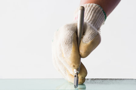 Glass technicians are cutting glass using glass tools according to the customer's order.の写真素材
