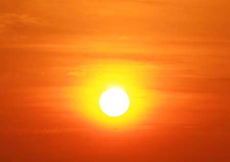 The sun rises in the morning with a light yelloworange sky.の写真素材