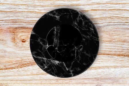 Black marble plate placed on wood.の写真素材