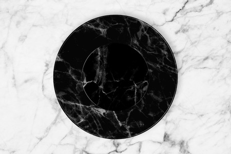 Black marble plate placed on white marble slab.の写真素材
