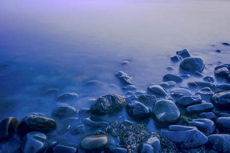 Mystical blue stones. Stones of the blue coast. Twilight at sea. Twilight and stones. Stones and water. Blue water and stones.の写真素材