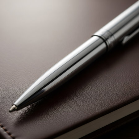 Close-up shot of a shiny silver pen placed on a textured brown leather surface, showcasing the pens design and the materials details.の素材