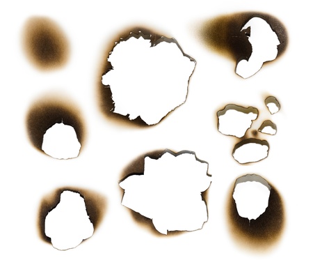 Collection of burnt holes in a piece of paper isolated on white backgroundの写真素材