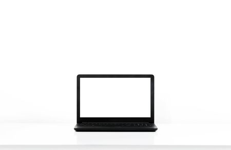Laptop, computer in home office, on white desk and bright wall behind. Modern workspace with copy...
